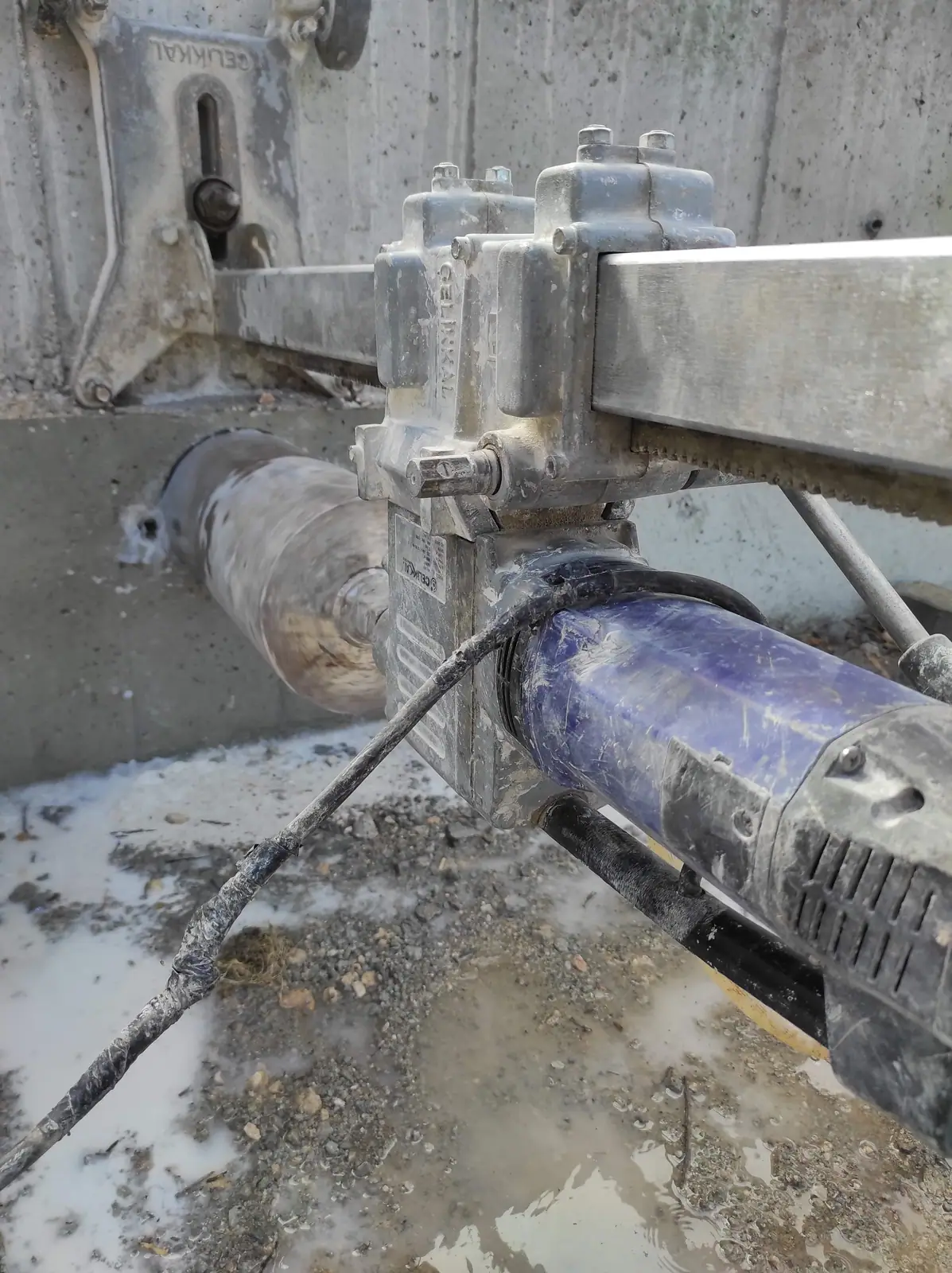 Beton duvara sabitlenmiş karot makinesiyle delik açma.